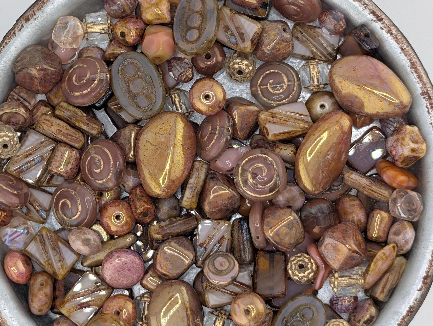 a collection of various beads and beads in different shapes and sizes, arranged in a bowl or container.