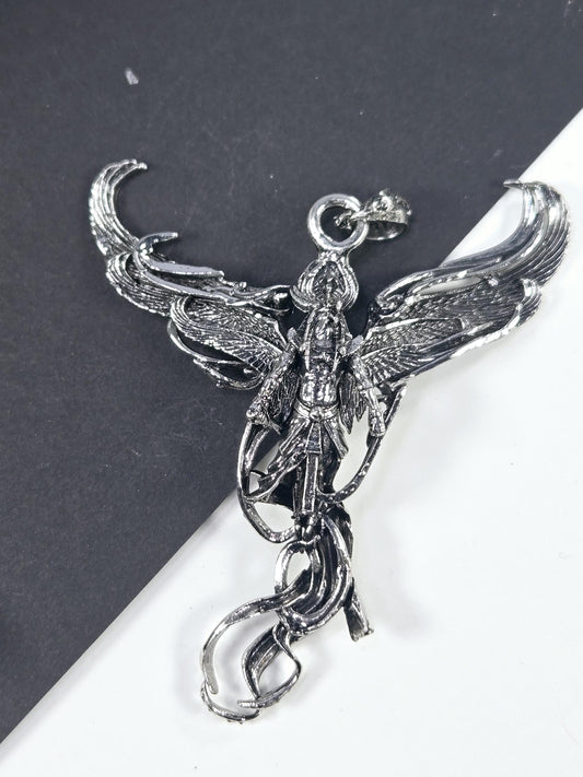 A silver-colored metal pendant in the shape of a bird, with intricate details and a decorative design.