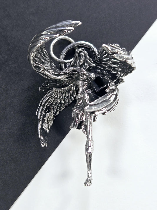 A silver-colored metal sculpture of a bird or winged creature, with intricate details and a metallic sheen.