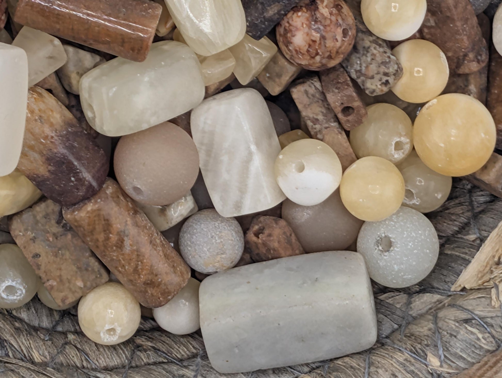 a collection of various natural objects, including beads, stones, and other minerals, arranged together.