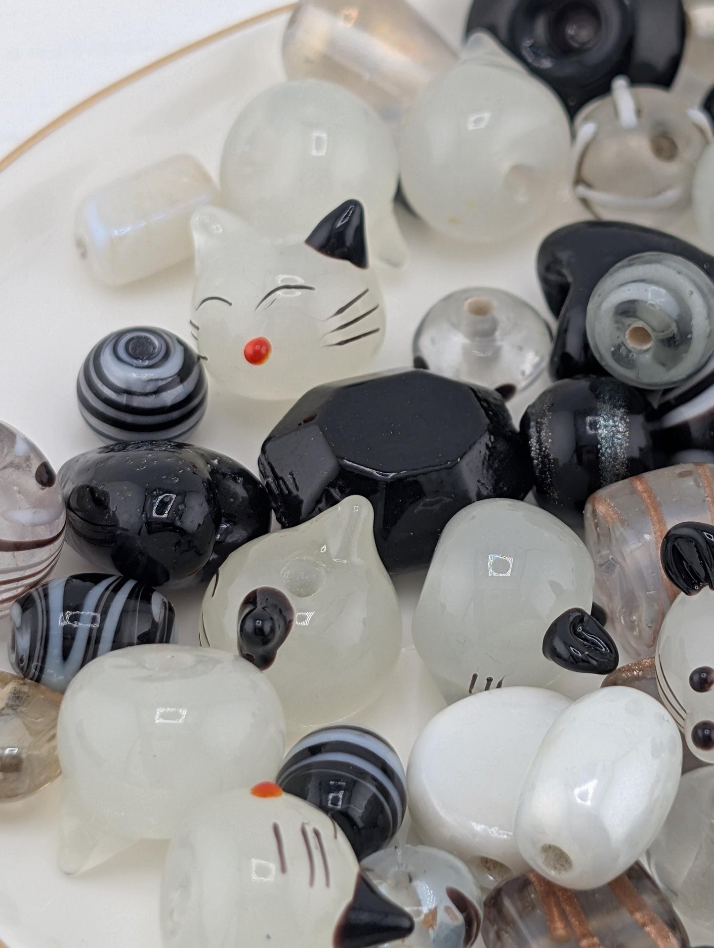 a variety of colorful beads, including black, white, and multicolored beads, arranged on a surface.