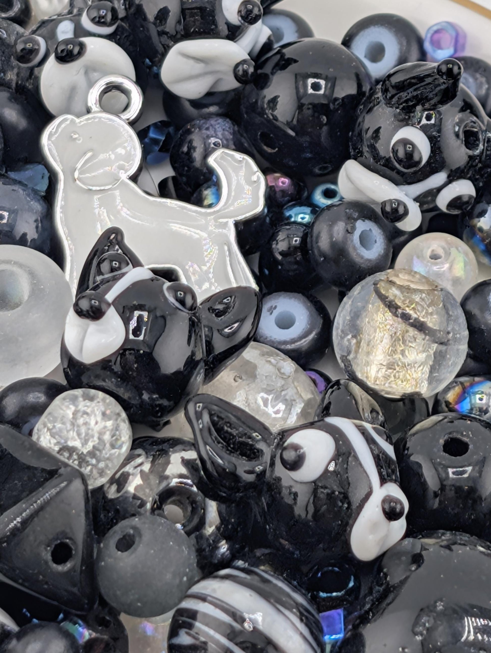 a variety of black and white beads, charms, and glass beads, creating a visually striking and diverse collection.