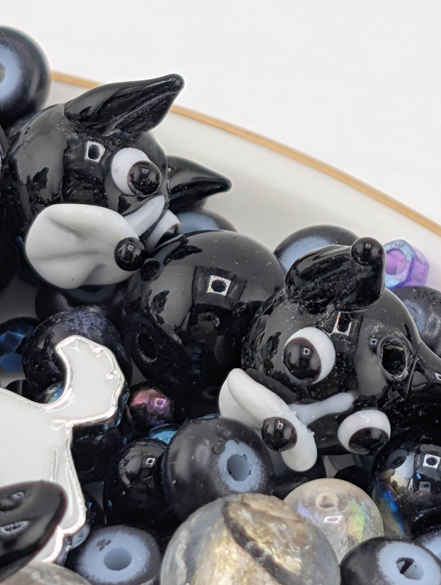 a collection of black and white ceramic or glass figurines, including two cat-like figures, arranged on a surface.