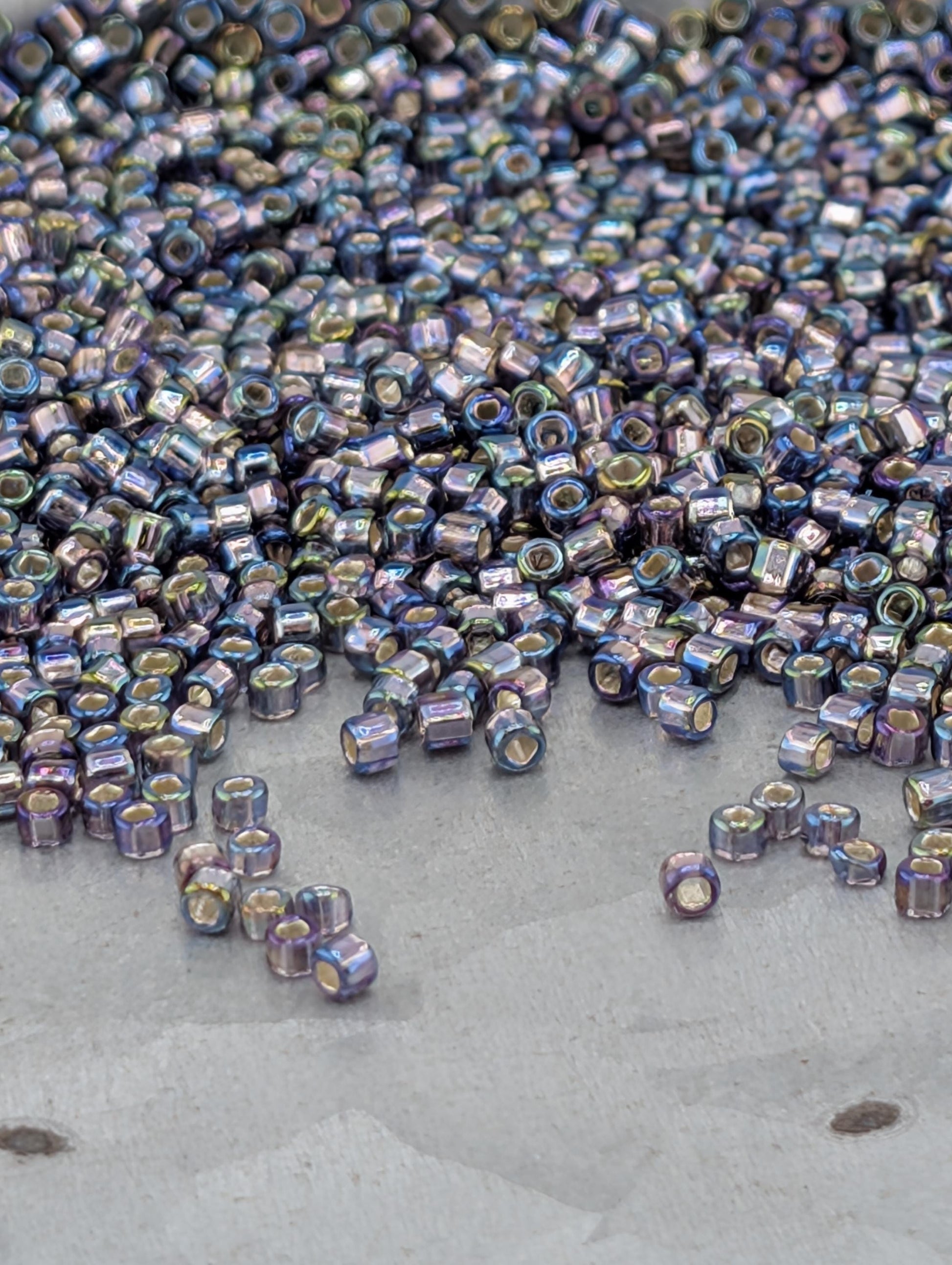 a large pile of multicolored beads scattered on a surface, with some of the beads falling off the edge.