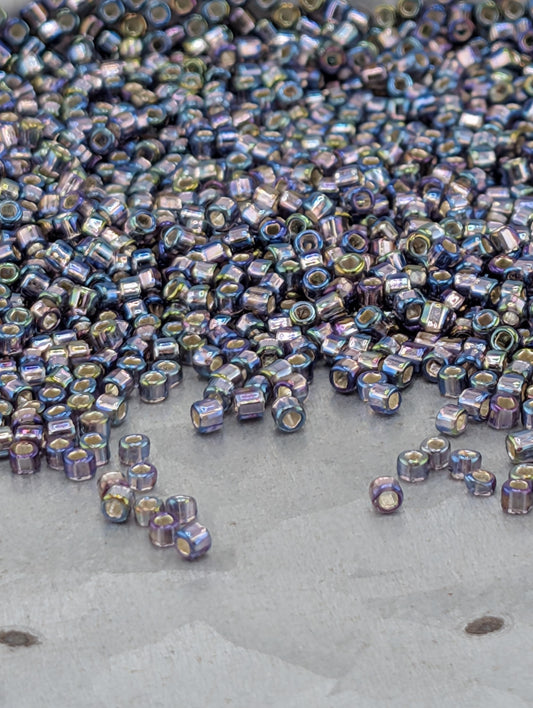 a large pile of multicolored beads scattered on a surface, with some of the beads falling off the edge.