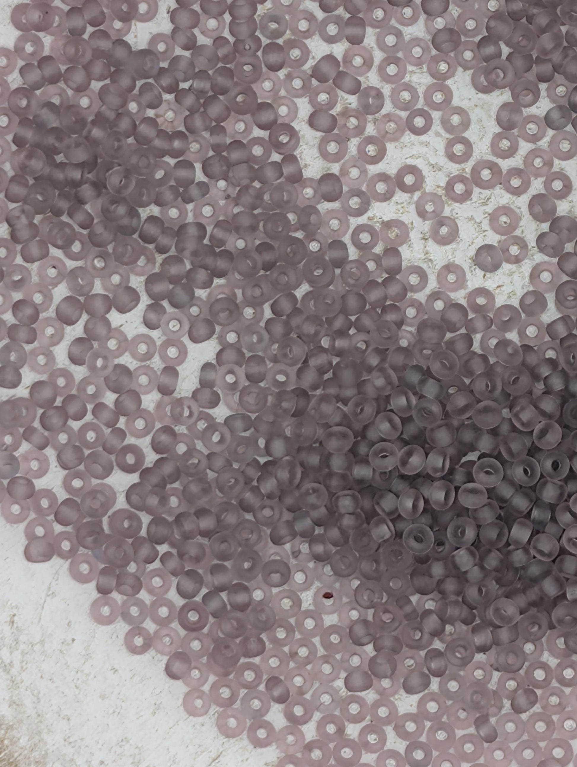 numerous small, round beads in various shades of gray, scattered across a surface.