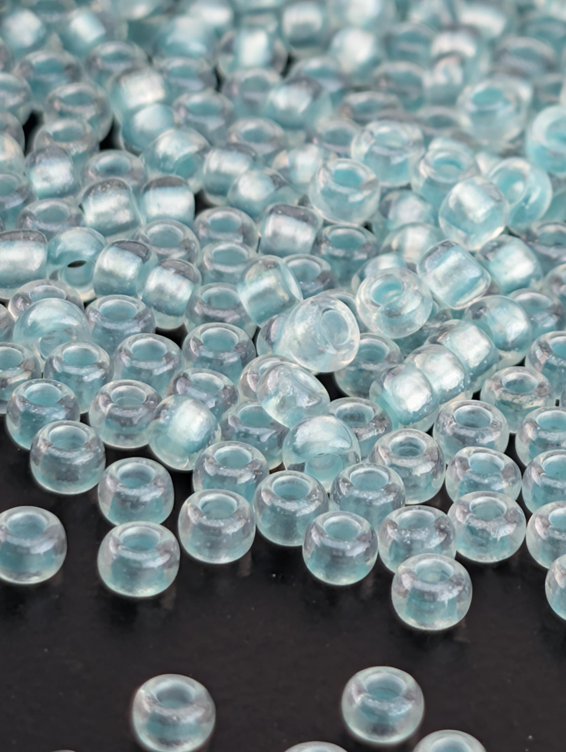 a collection of clear glass beads scattered on a dark background.