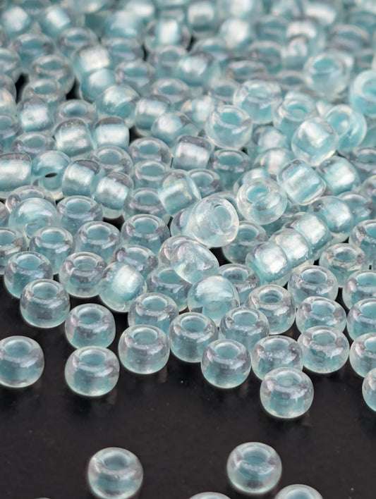 a collection of clear glass beads scattered on a dark background.