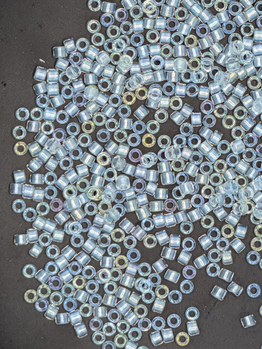 a collection of small, clear beads scattered on a dark surface.
