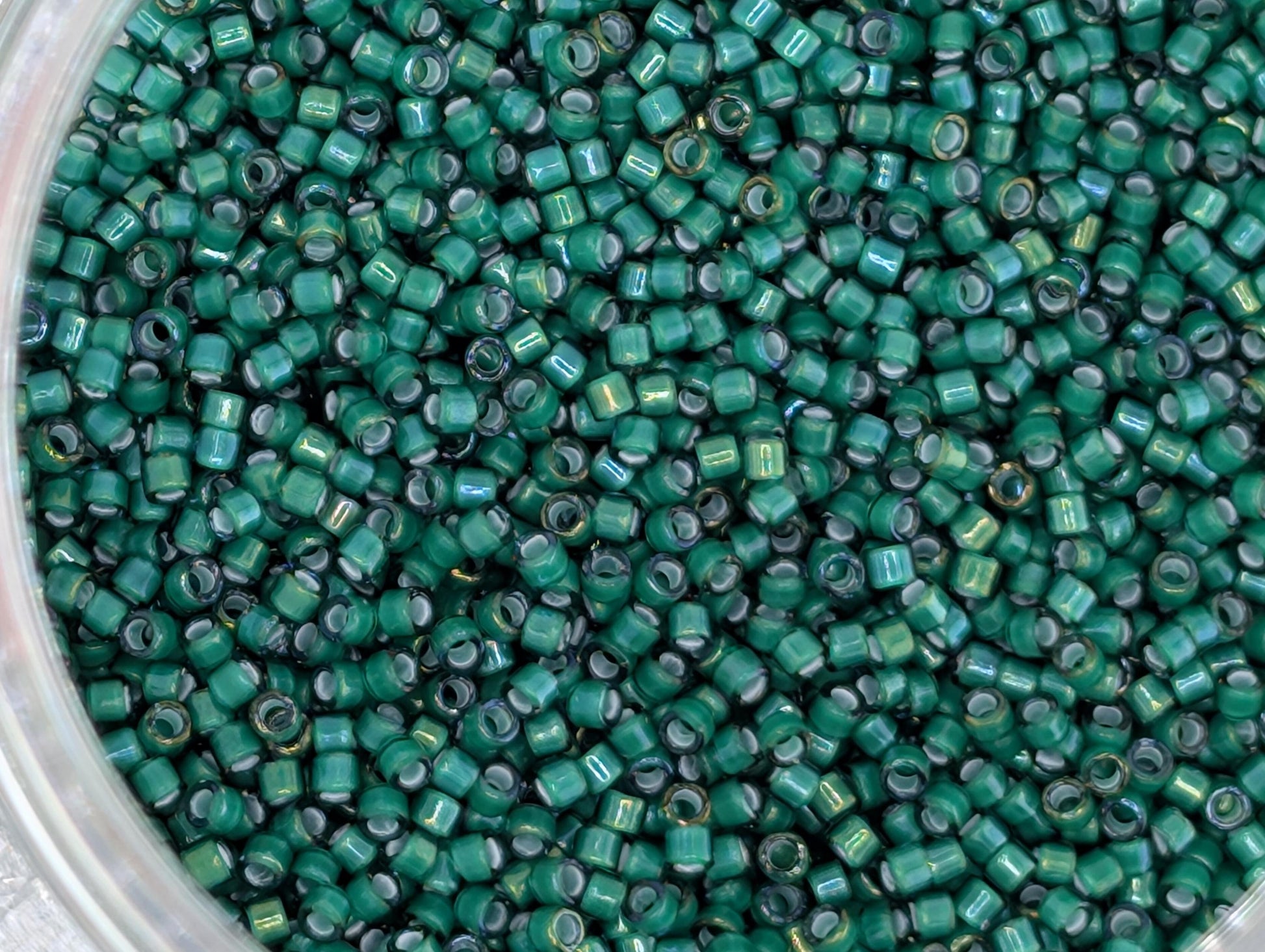 A close-up image of a large pile of green glass beads or beads, with a variety of sizes and shapes.