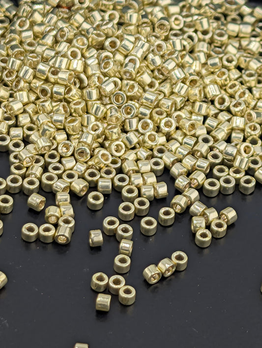 a pile of small, round, metallic beads or nuts scattered on a dark surface.