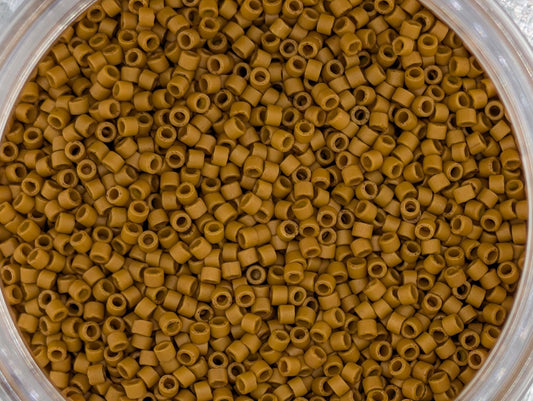 A close-up image of a container filled with small, round, brown objects, likely beads or grains, arranged in a visually appealing manner.