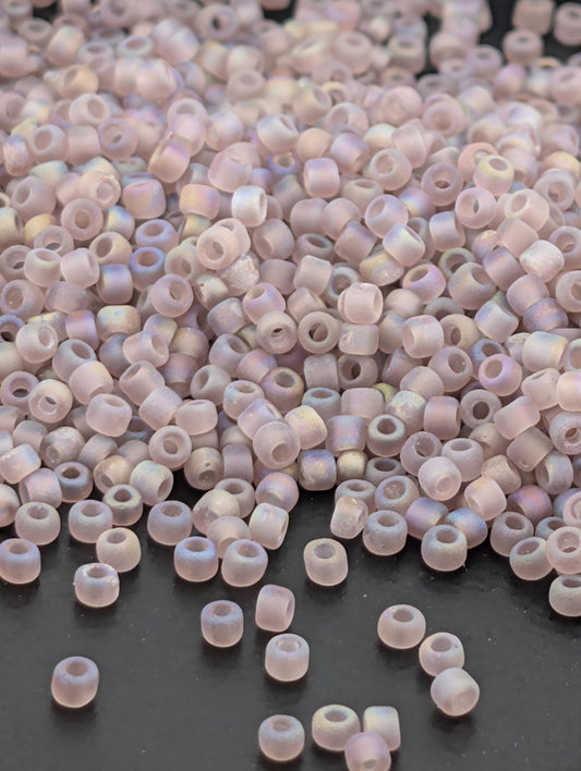 a large pile of small, round beads scattered on a dark surface.