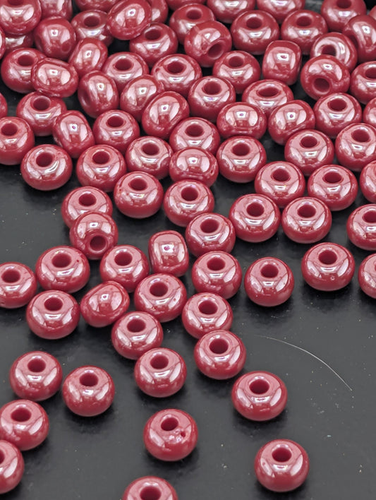 a large number of small, round, red beads scattered across a dark surface.