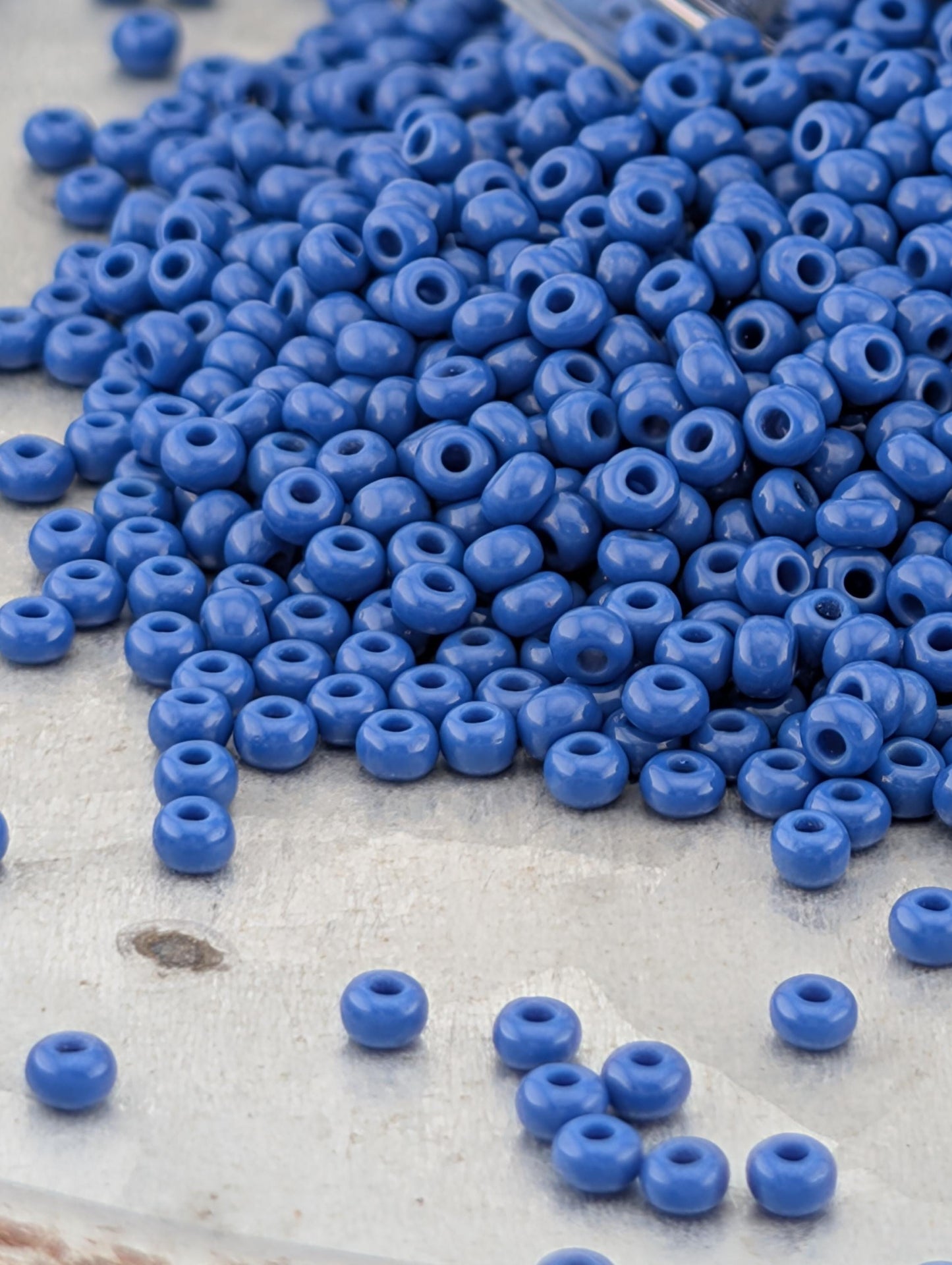 A pile of blue beads on a white surface.