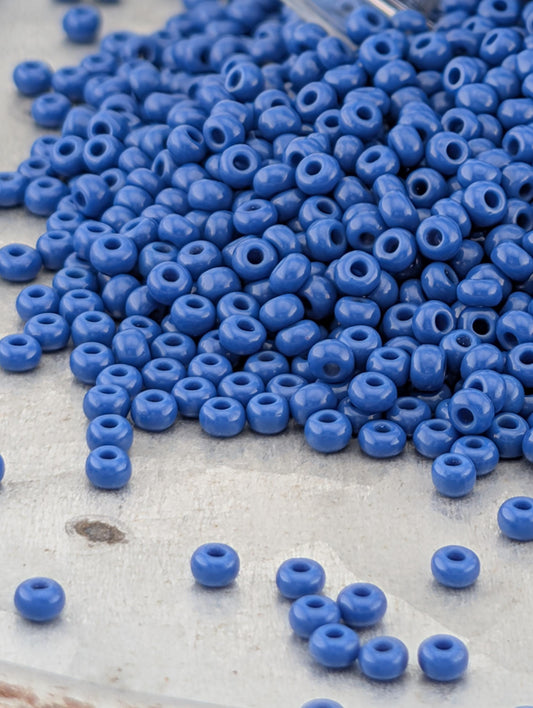 A pile of blue beads on a white surface.
