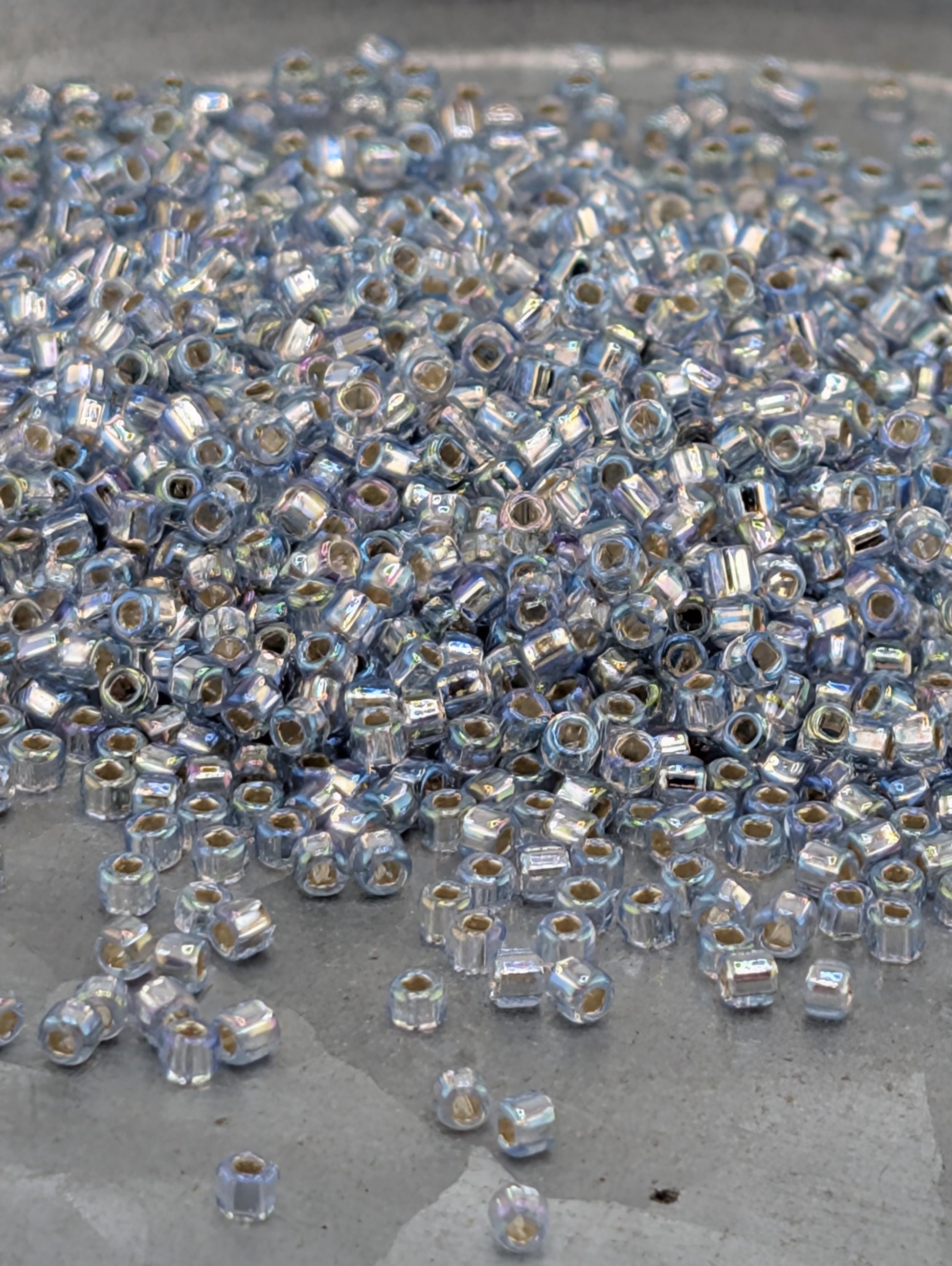 a large pile of small, clear beads scattered on a surface.