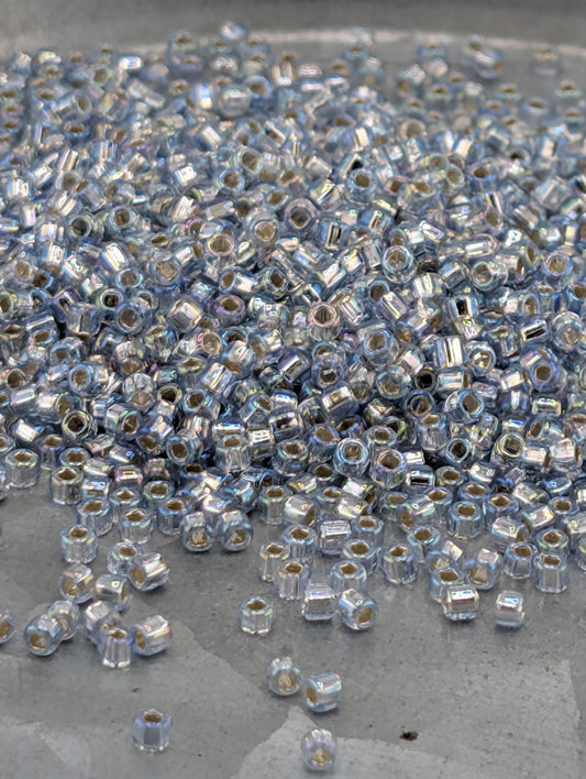 a large pile of small, clear beads scattered on a surface.