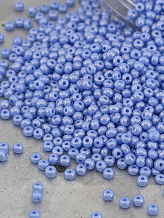 a pile of small, round, blue beads scattered on a surface.