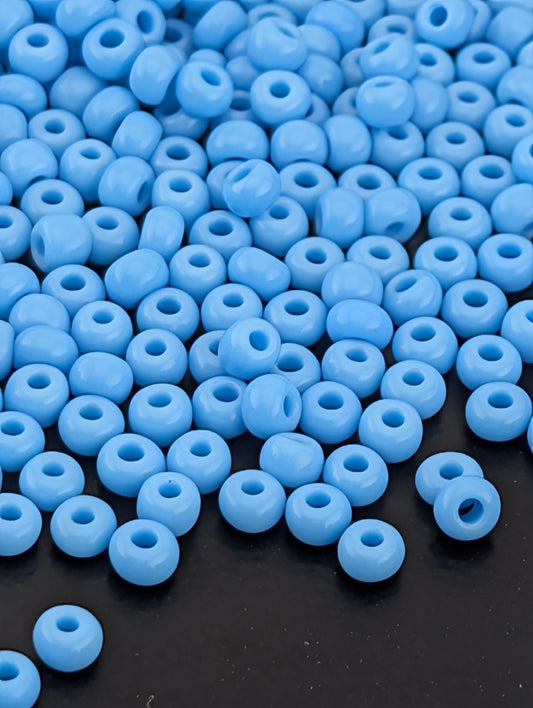 a large number of small, round blue beads scattered across a dark background.