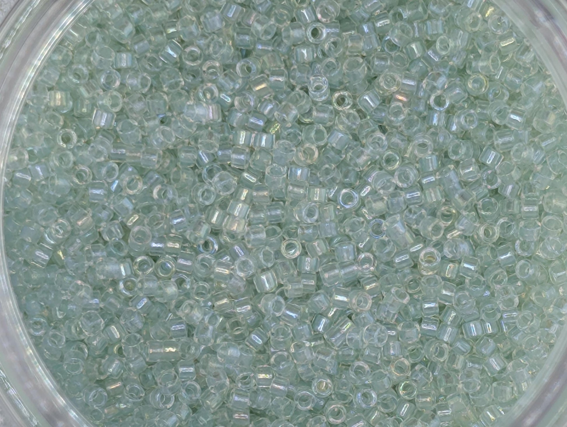 A close-up image of a transparent material, possibly glass or plastic, filled with small, clear beads or grains.
