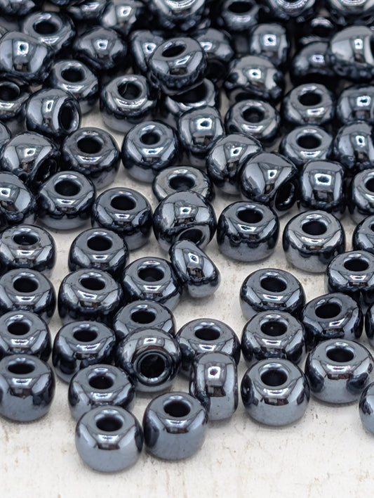 a collection of small, shiny black beads scattered across a surface.
