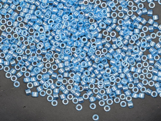 a large number of small, round blue beads scattered across a dark surface.