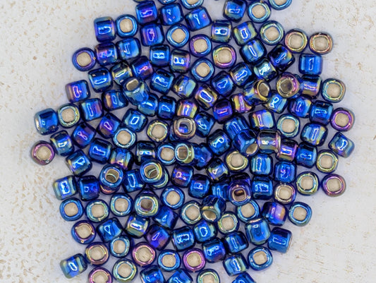 a collection of blue and purple beads scattered on a white surface.
