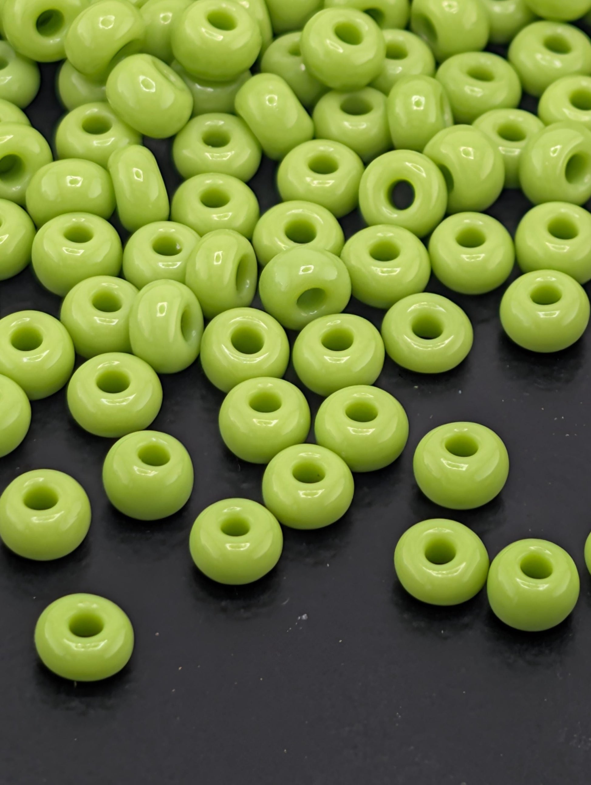 a collection of neon green beads scattered on a dark surface.