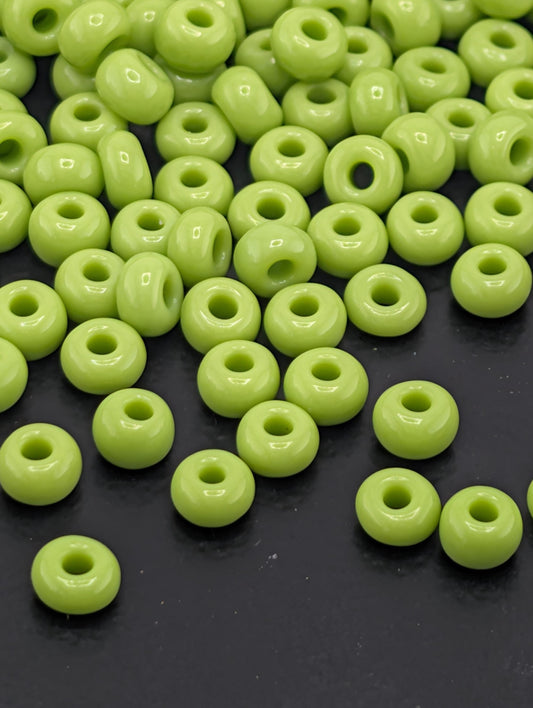 a collection of neon green beads scattered on a dark surface.