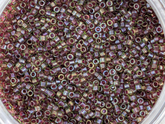 A close-up image of a large pile of small, round beads in various shades of purple and green.