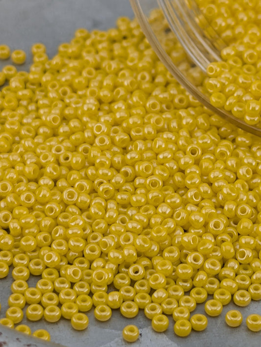 A pile of yellow beads on a gray surface.