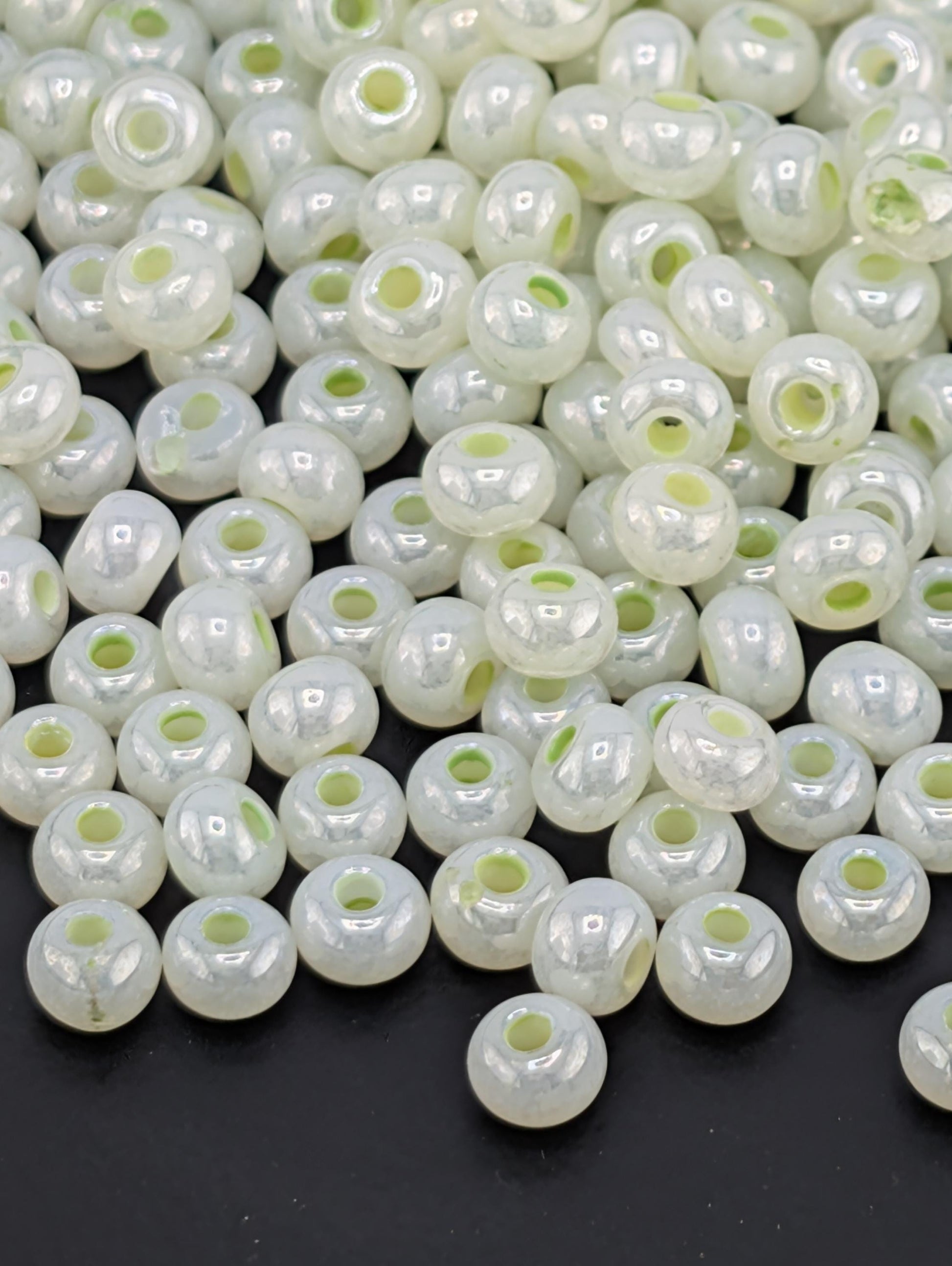 a large pile of white, round beads scattered on a dark background.