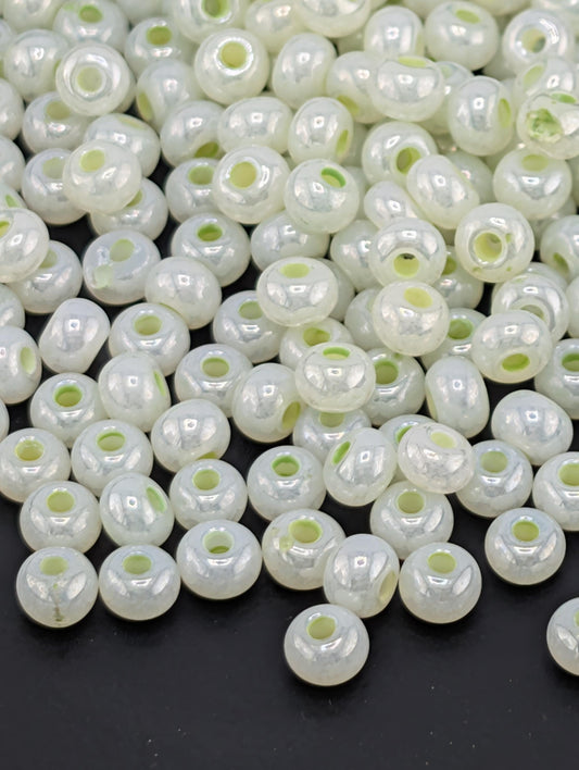 a large pile of white, round beads scattered on a dark background.