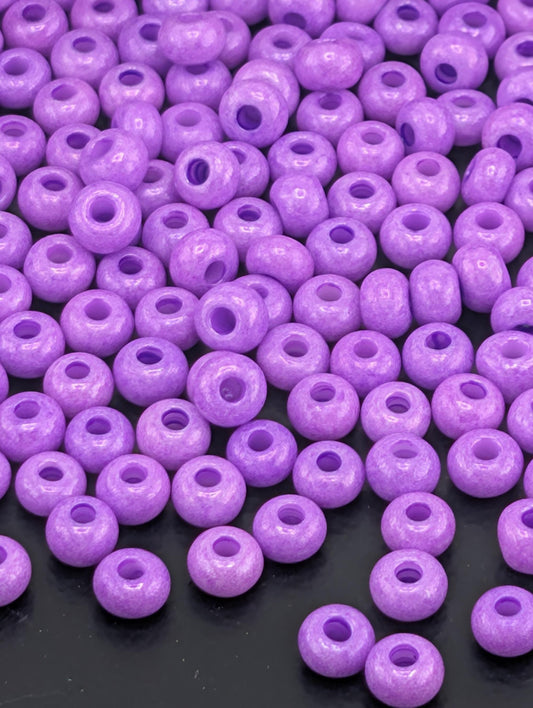 a collection of purple beads scattered across a dark background.