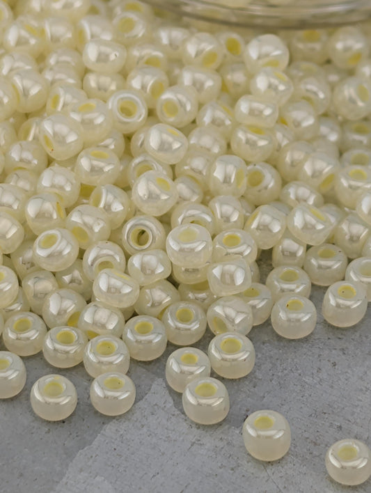 a large pile of small, white beads scattered on a surface.