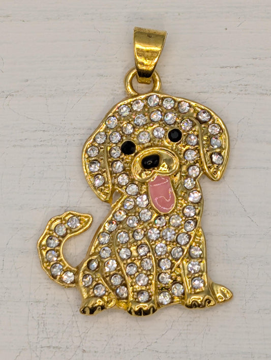 A gold-colored charm in the shape of a dog, adorned with numerous sparkling rhinestones.