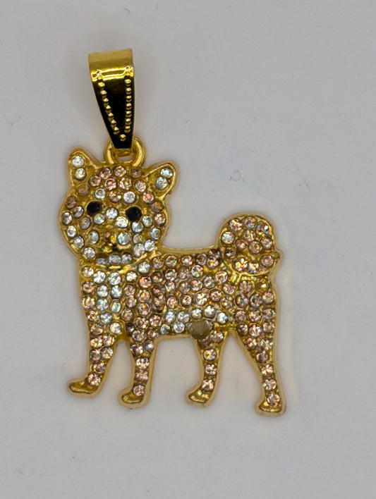 A gold-colored pendant in the shape of a dog, adorned with numerous small diamonds or gemstones.