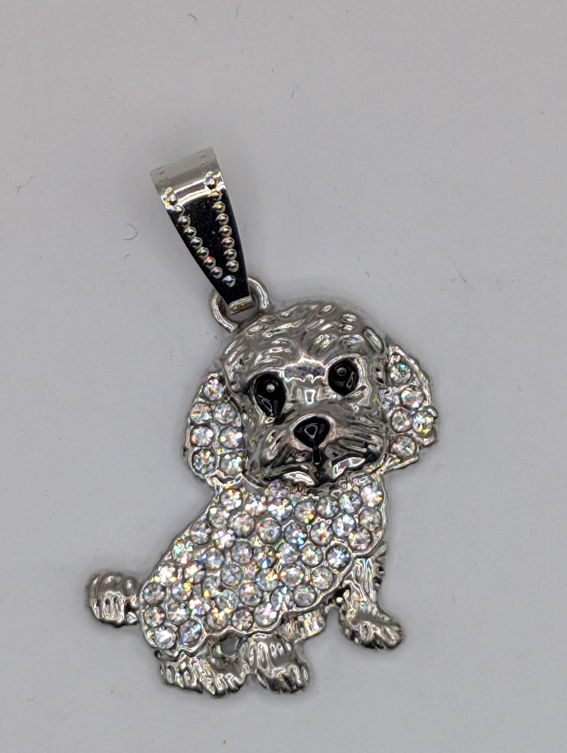 A silver-colored poodle charm with a sparkling crystal design.