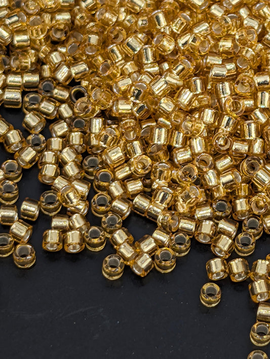 a close-up view of numerous small, clear glass beads scattered across a dark background.