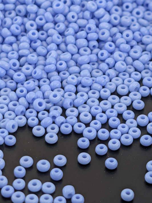 a large number of small, round beads in various shades of blue, scattered across a dark background.