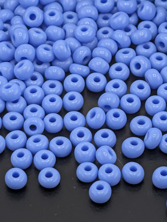 a collection of small, round, blue beads scattered on a dark surface.