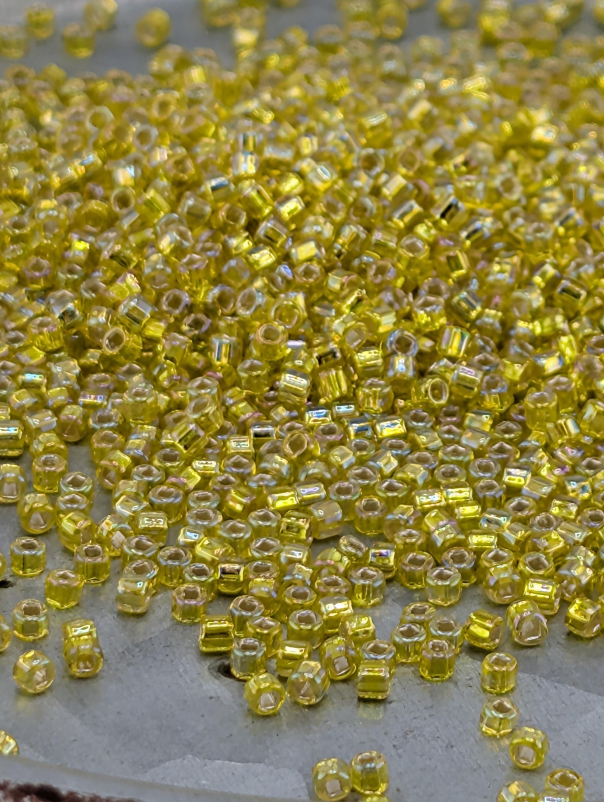 a close-up view of numerous small, yellow beads scattered across a surface.