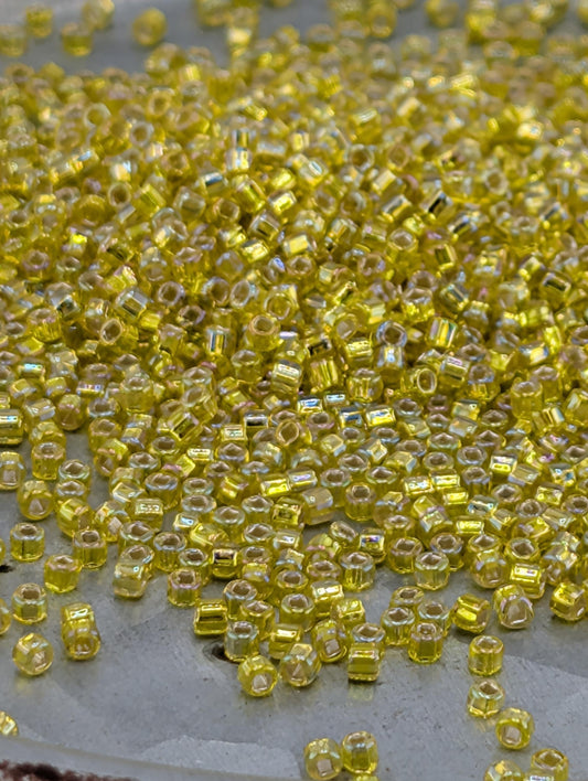 a close-up view of numerous small, yellow beads scattered across a surface.