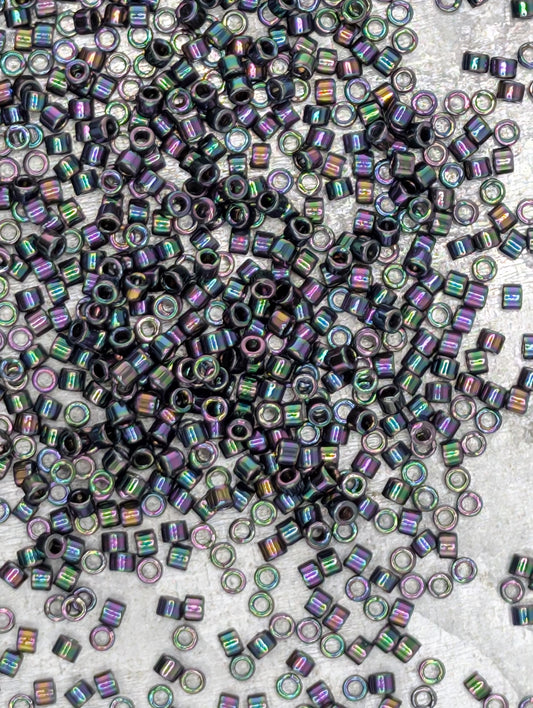 The image is a close-up of numerous small, multicolored beads or sequins scattered across a surface.