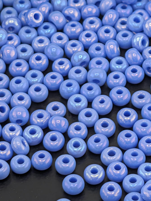 a collection of small, round, blue beads scattered across a dark background.
