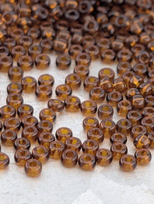a collection of brown glass beads scattered on a white surface.