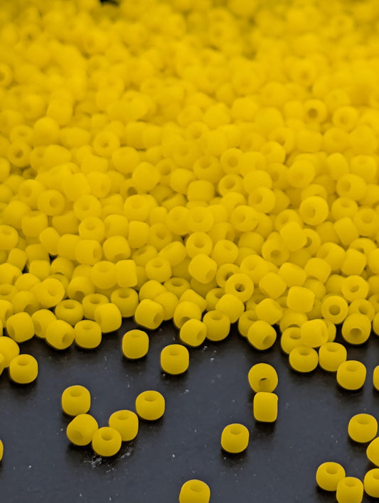 a large pile of yellow beads or objects scattered on a dark surface.