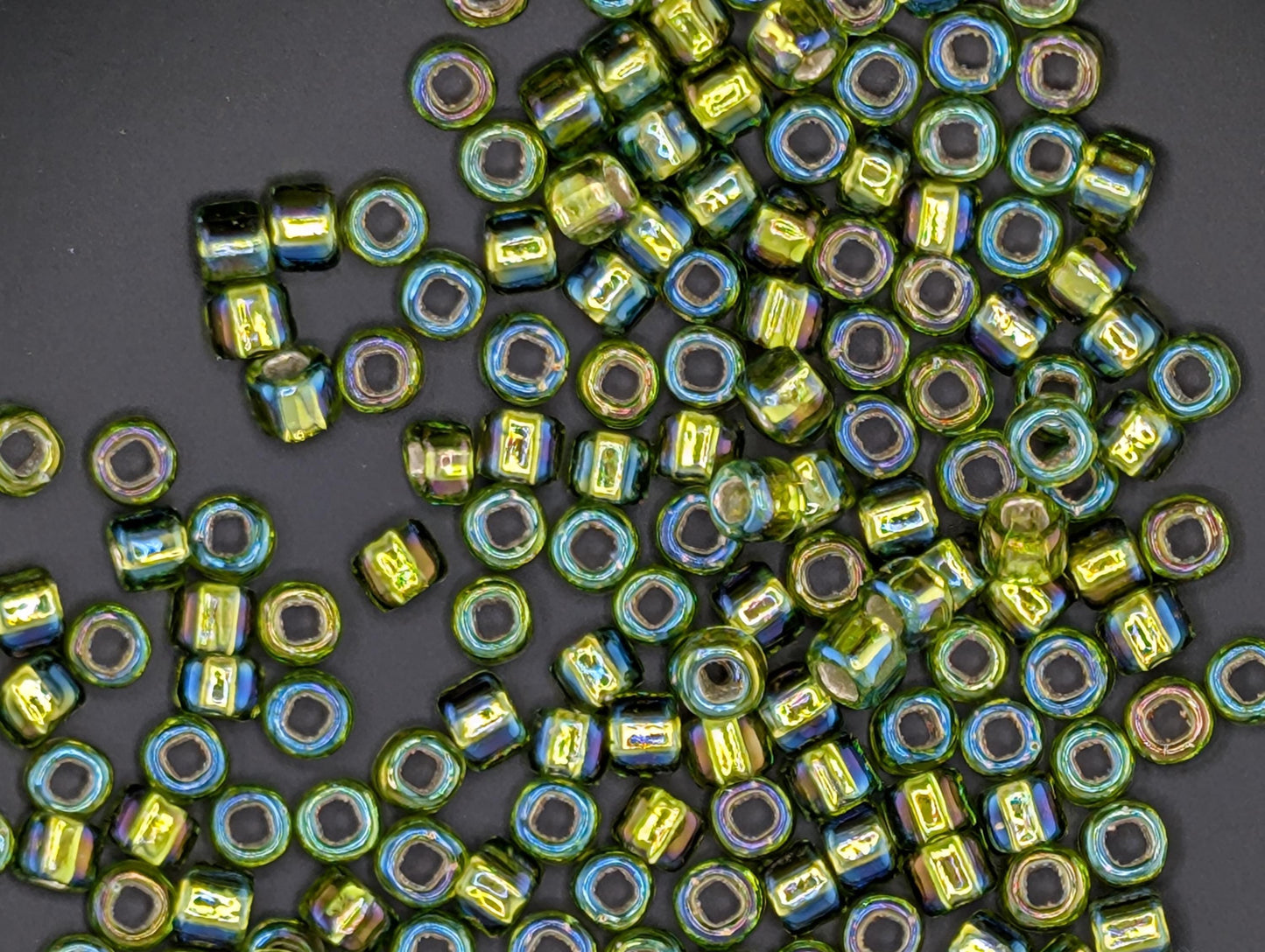 a collection of colorful glass beads scattered on a dark background.