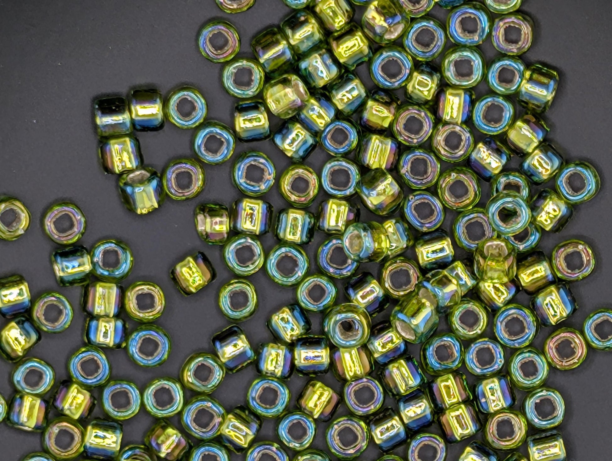 a collection of colorful glass beads scattered on a dark background.